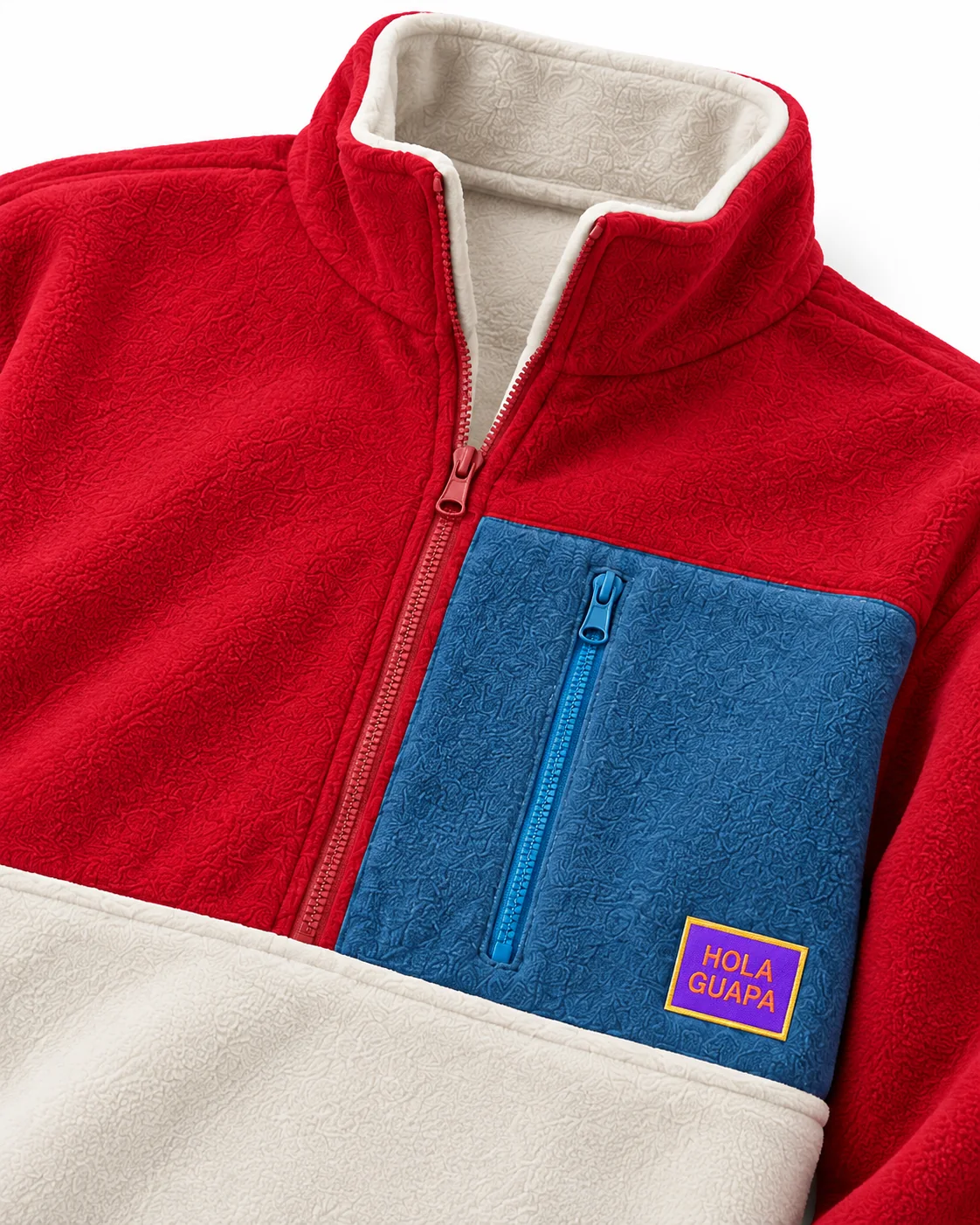 Close-up van de kraag, ritsen, stofstructuur en het Hola Guapa-label van de fleece